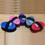 Cinque brusconi Groovy ovali blu, rosa, viola, grigio e rosso con cinghia nera su piano di legno.