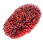 Bruscone ovale con setole fitte rosso acceso e nere, base in plastica, su sfondo bianco.